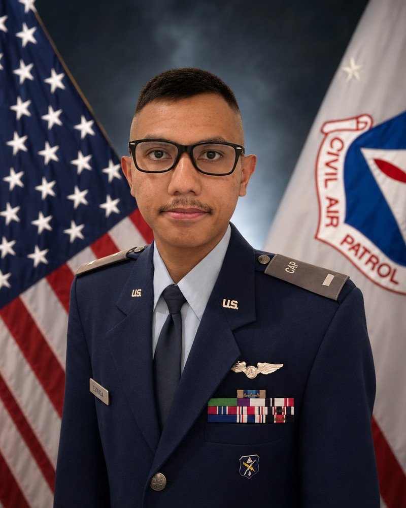 Aaron John Estrada in Civil Air Patrol service dress uniform, standing before the United States and Civil Air Patrol flags.
